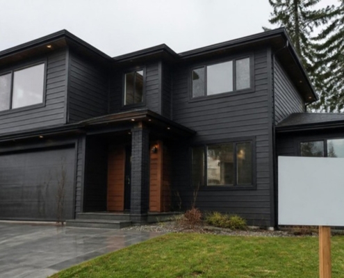 A freshly renovated house exterior with a blank sign post on the lawn.