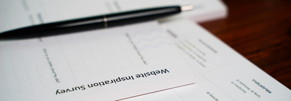 A pen lying across a printed document on a desk.