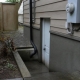 A separate basement suite entrance with its own door and concrete steps.