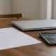 A lender's letter, a calculator and a laptop on a dining table.
